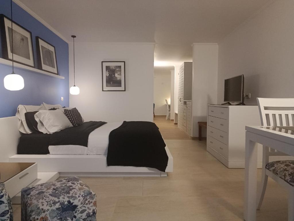 波帕扬康福特精品酒店的卧室配有白色的床和电视