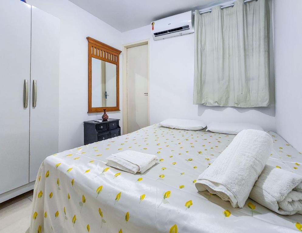 玛丽亚法里尼亚Apartamento Maria Farinha的白色卧室,床上有黄色的鲜花