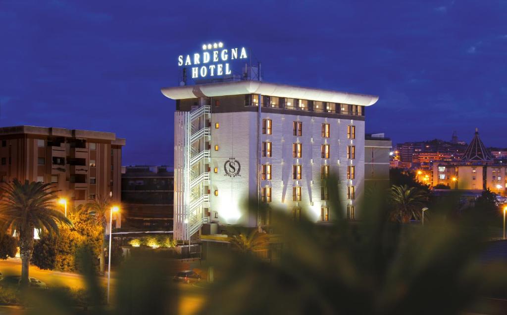 卡利亚里撒丁岛套房和餐厅酒店的一家晚上在上面标有标志的酒店