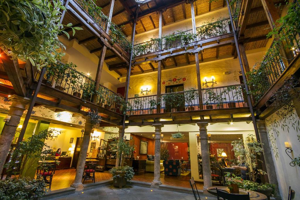 基多La Casona de la Ronda Hotel Boutique & Luxury Apartments的带阳台和植物的大型建筑