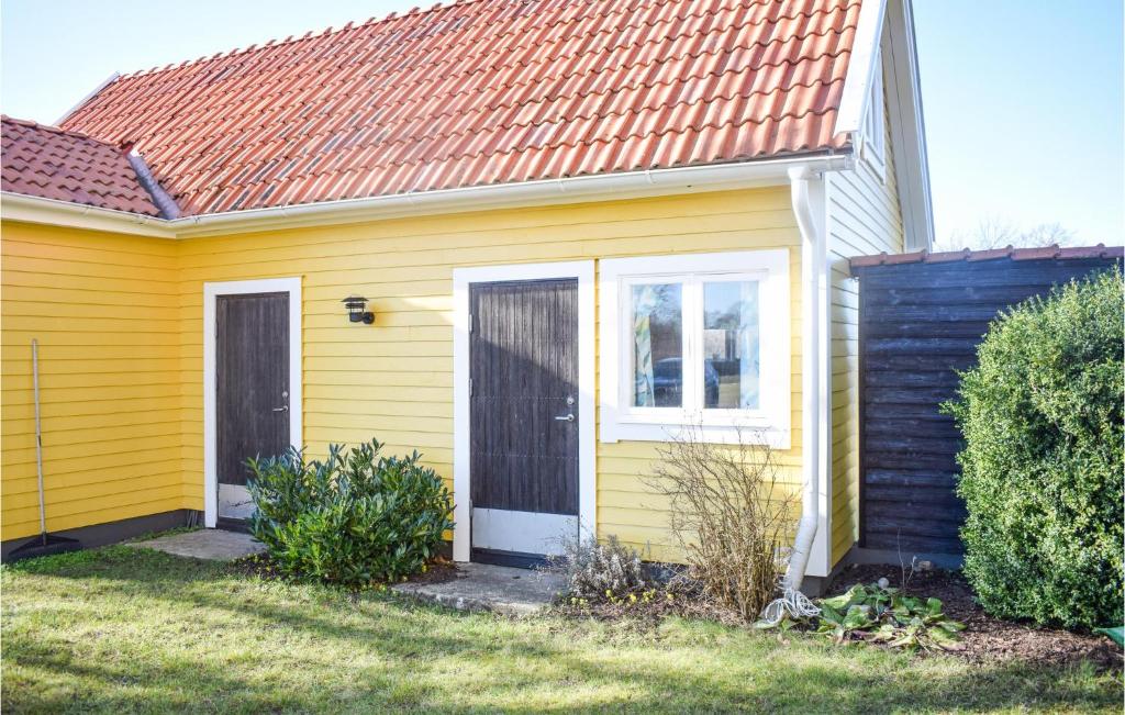 费尔耶斯塔登Beautiful Home In Frjestaden With Kitchen的黄色的房屋,有红色的屋顶