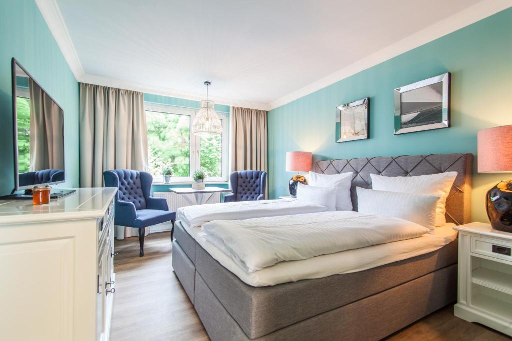 朗格奥Lieblingsinsel Langeoog的酒店客房带一张床、一张桌子和椅子