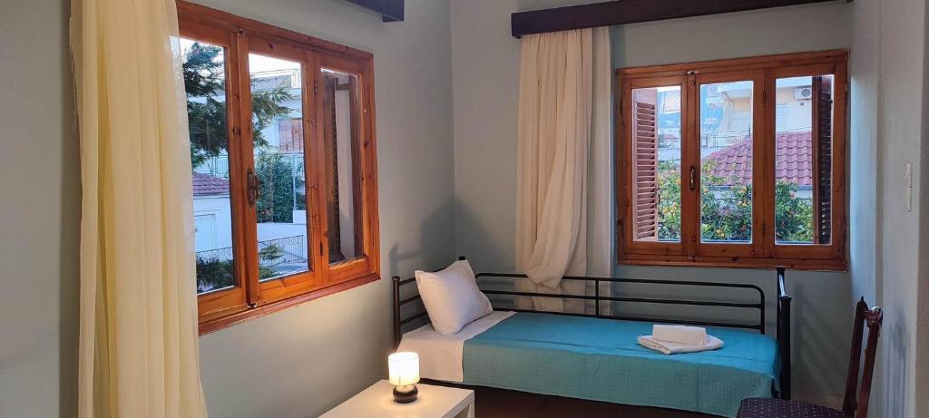 新安希亚洛斯Anchialos seafront appartement的一间小卧室,配有床和2个窗户