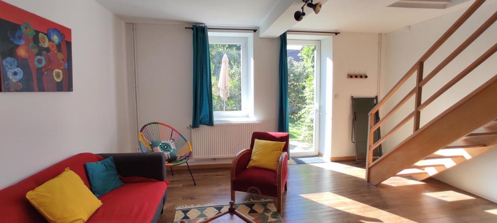 BlaudeixLe nid d'Eugénie的客厅配有红色的沙发和两把椅子
