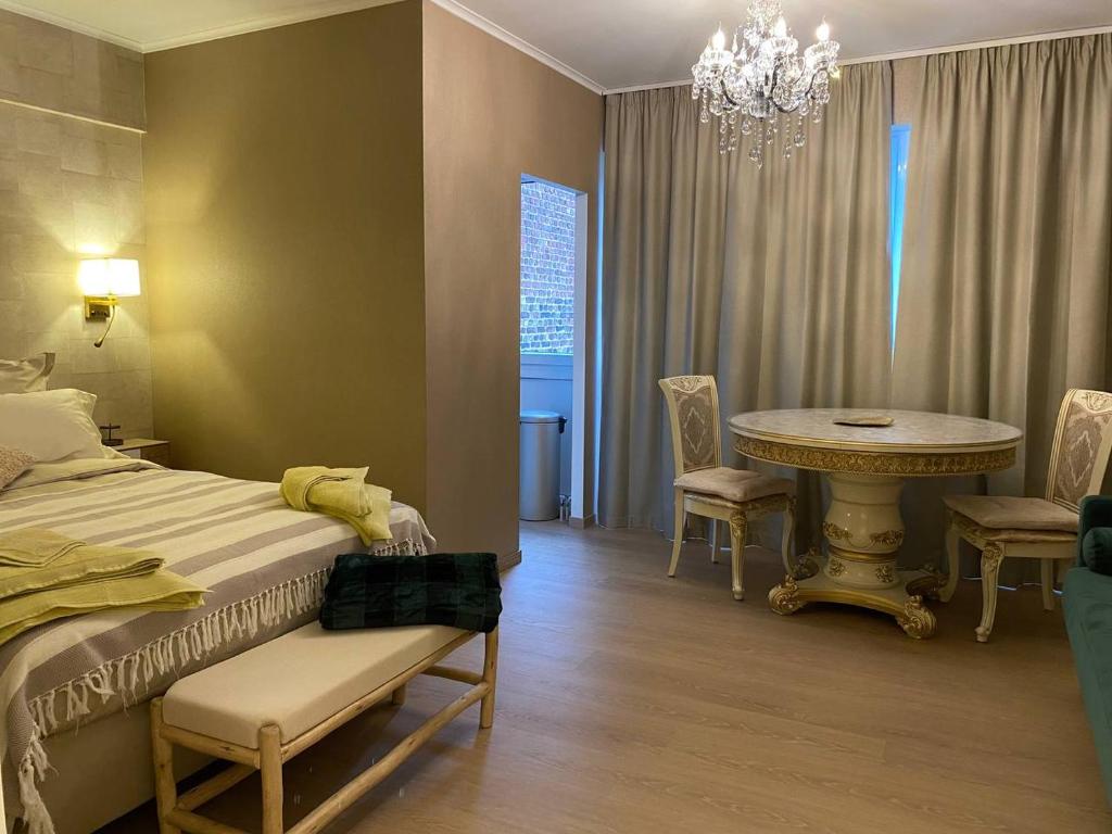 列日Studio Montaigne的一间卧室配有一张床、一张桌子和一个吊灯。