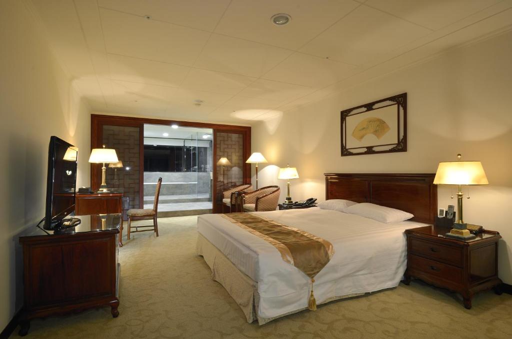中坜景园大饭店的酒店客房设有一张大床和一张书桌。