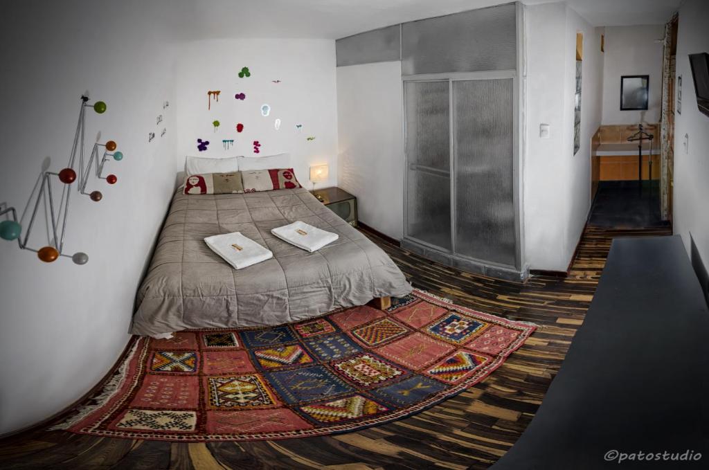阿雷基帕布巴马拉旅馆的卧室配有一张铺在地板上的地毯。