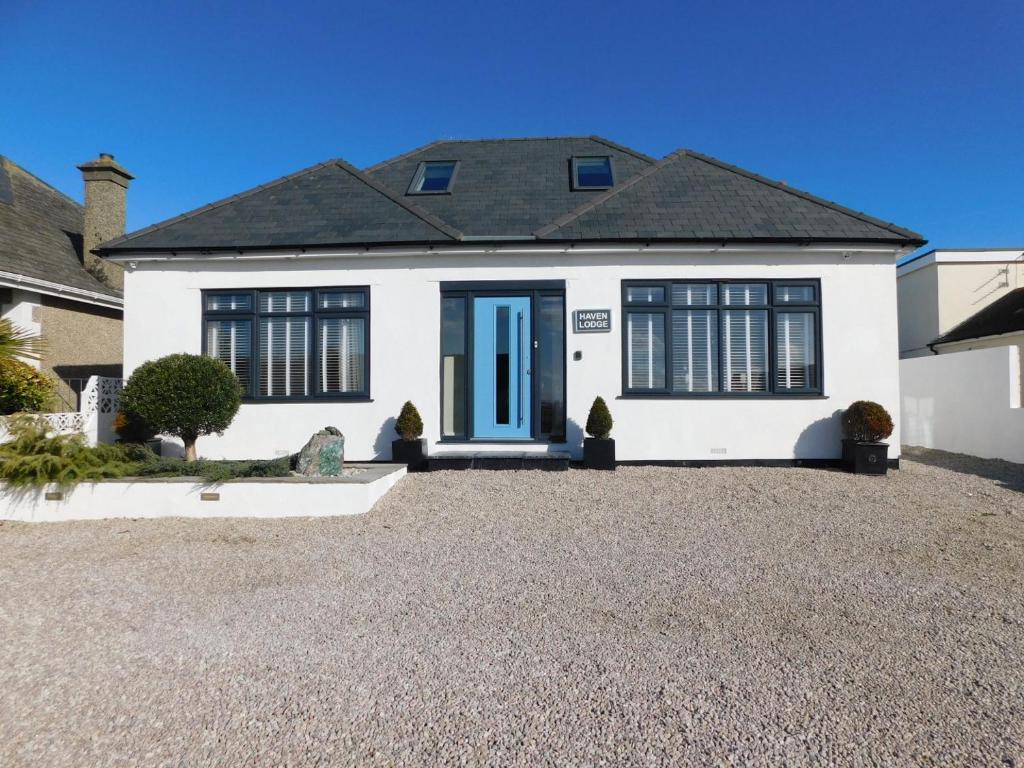 纽基Haven Lodge Newquay的白色的房子,有蓝色的门