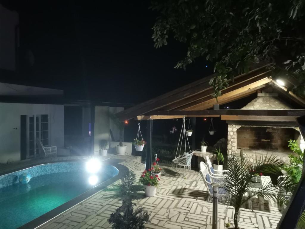 图兹拉Apartment holidays and partys with a pool的一座晚上设有游泳池的房子