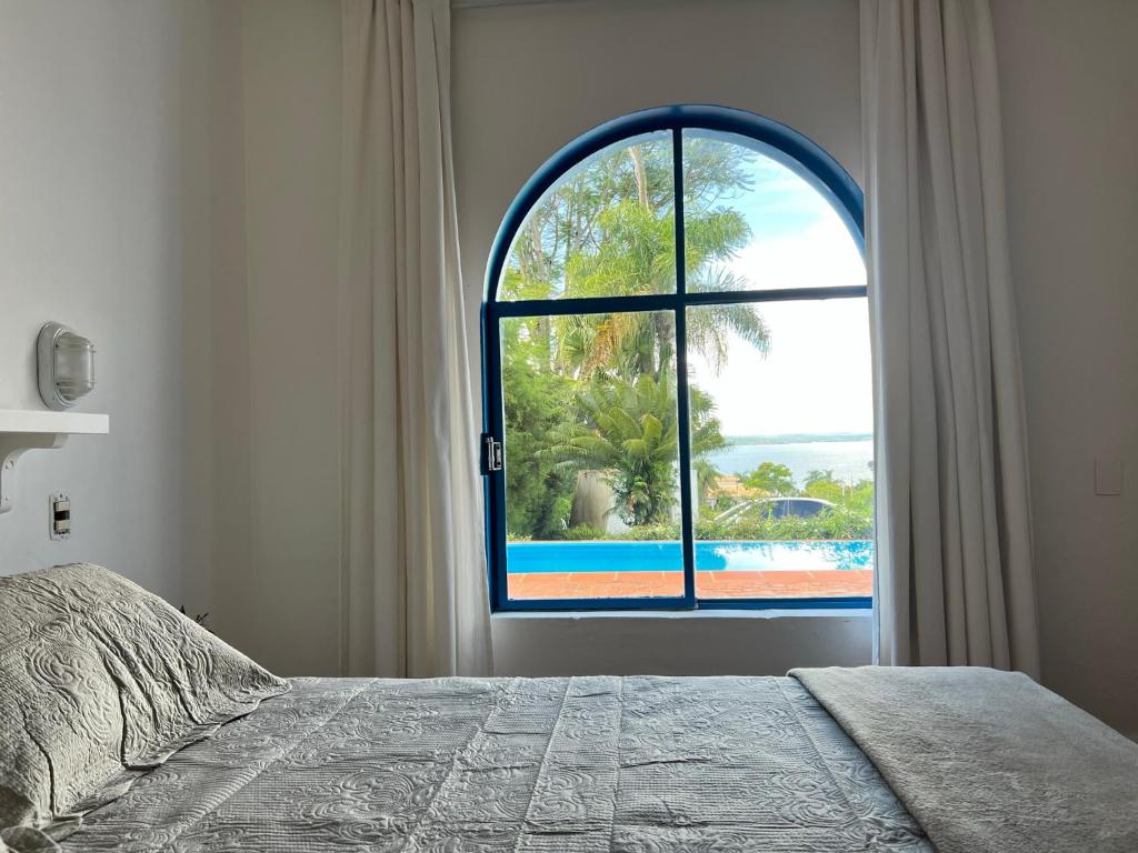 ItaíCasa Mykonos Represa Avaré的一间卧室设有一张床和一个大窗户
