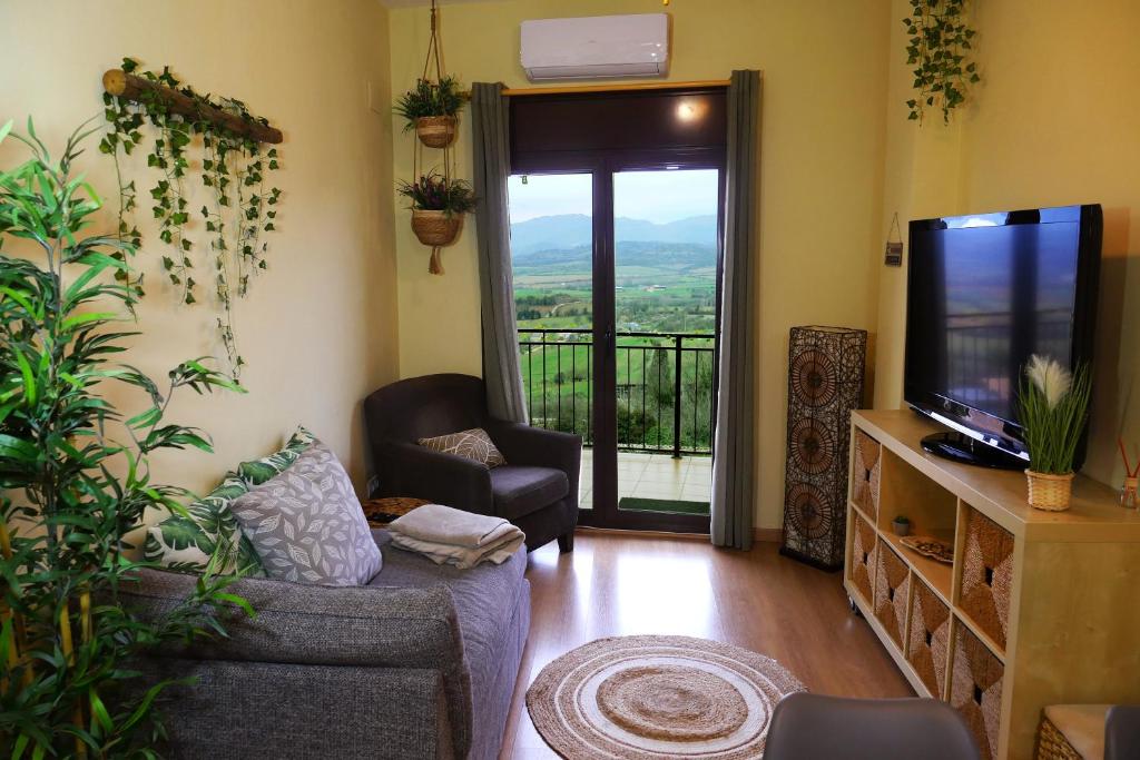 TalarnGrace, apartamento con terraza y vistas的带沙发和电视的客厅以及阳台。