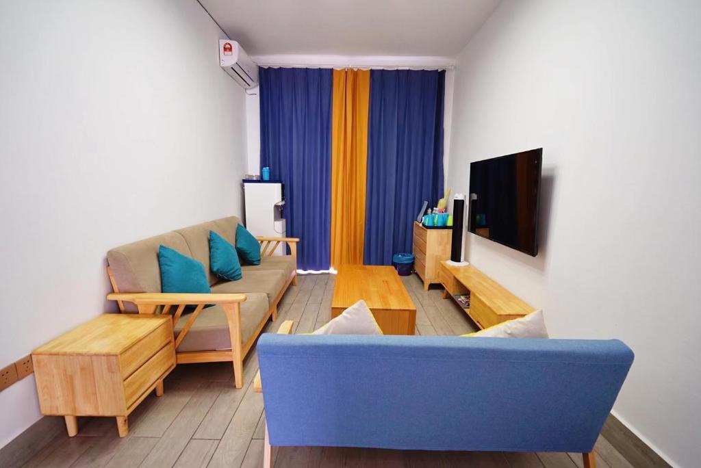 仙本那See西柚you hotel的客厅配有蓝色的沙发和电视