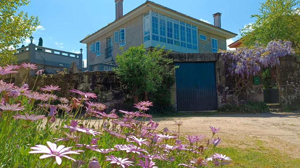 贡多马尔Casa Estarque的蓝色车库和紫色鲜花的房子