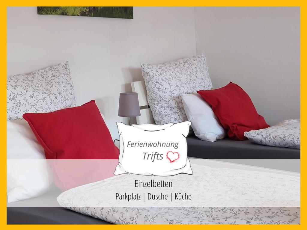 万根伊姆阿尔戈伊Ferienwohnung Trifts | Einzelbetten | Parkplatz的客房设有带红色和白色枕头的沙发。