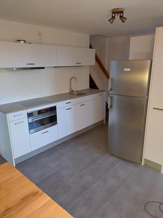 Erlach2 1/2 Zimmer Ferienwohnung的厨房配有白色橱柜和不锈钢冰箱