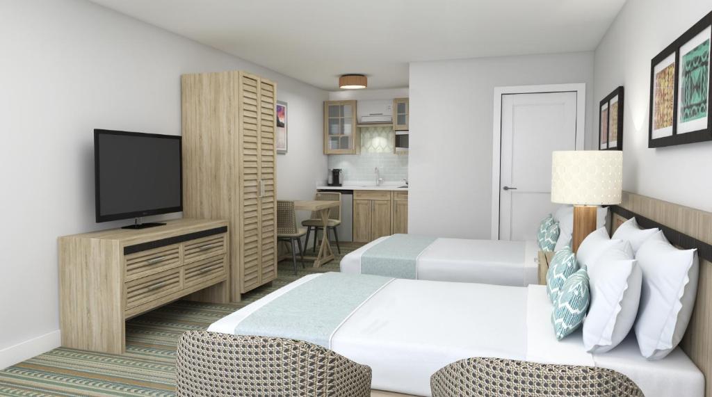 五月岬郡Mahalo Cape May的酒店客房设有两张床和一台平面电视。