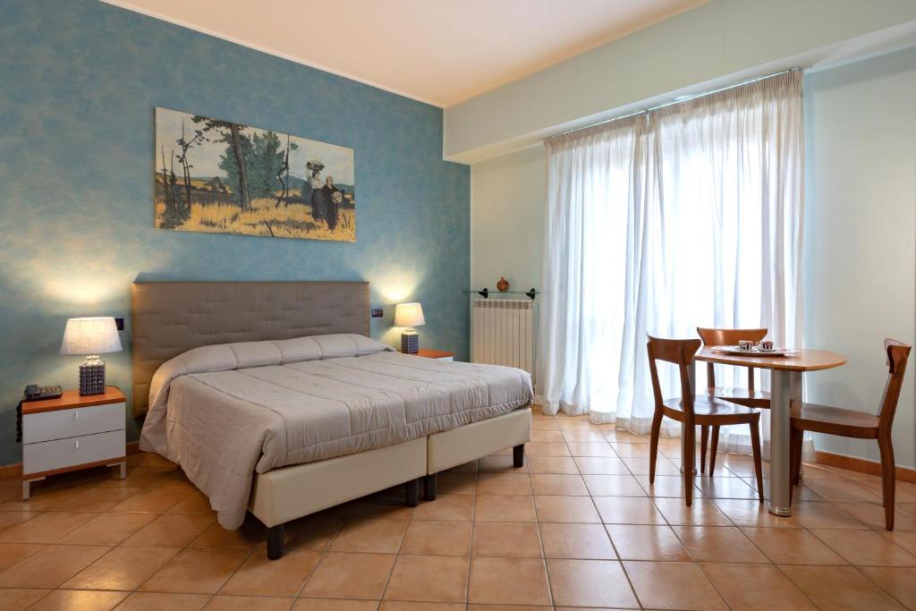 拉奎拉Hotel Azzurro的一间卧室配有一张床、一张桌子和一张书桌