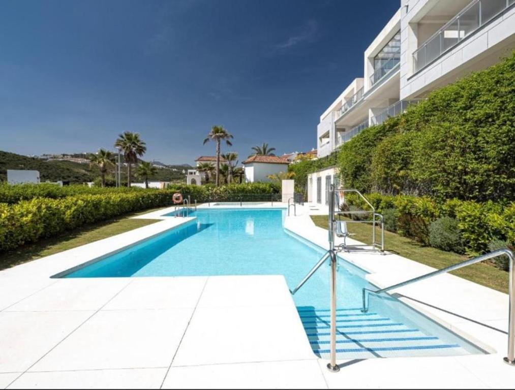 EsteponaAppartement Casares - Mer, Golf, Piscine, Padel - FINCA CORTESIN的大楼前的游泳池