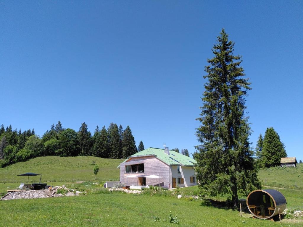 拉穆拉La Ferme du Lanchet的田野上的粉红色房子,有树
