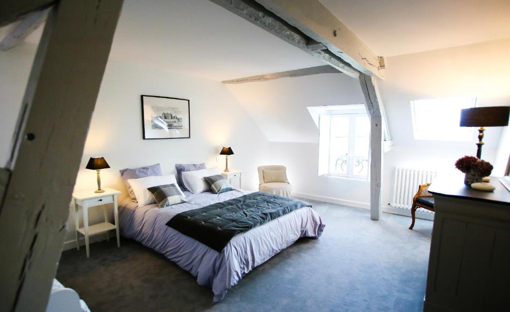 卢瓦尔河畔圣丹尼斯L’Atelier的一间卧室配有一张床、两把椅子和一个窗户