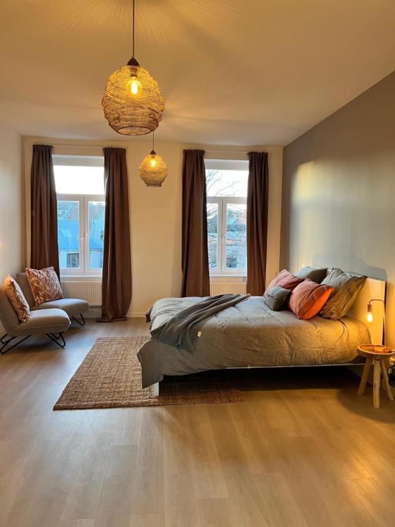 根特Holiday Home La Petite Maison的一间卧室配有一张床、一把椅子和窗户。