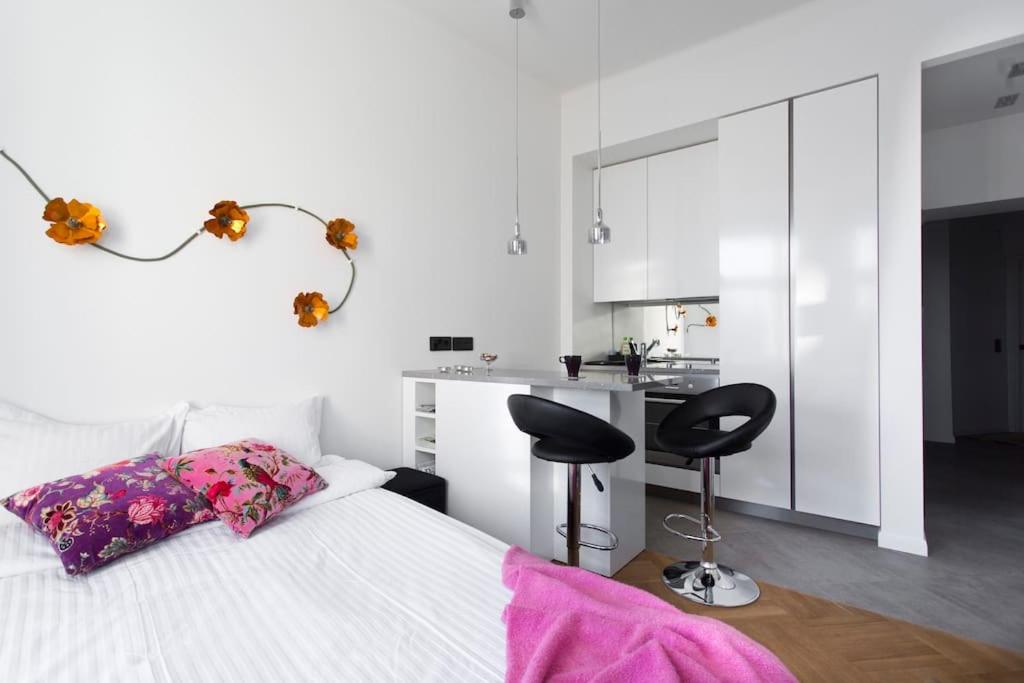 赫尔辛基Stylish studio in the centre的一间卧室配有一张带书桌和两把椅子的床。