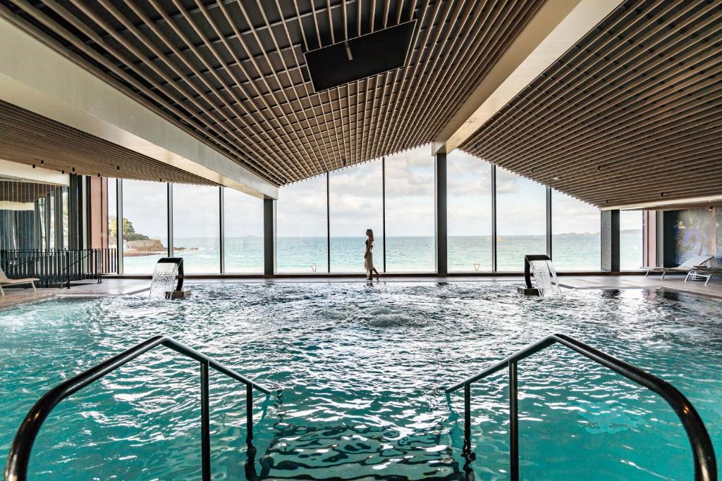 佩罗斯-吉雷克Hôtel Roz Marine Thalasso Resort的站在建筑物游泳池中的女人