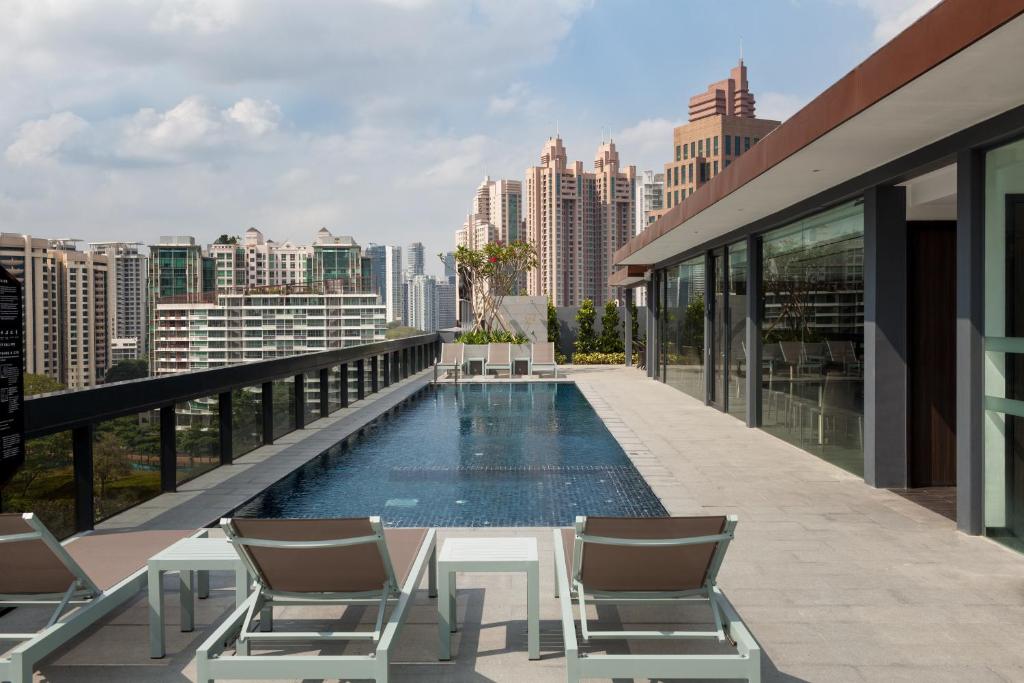 新加坡哈夫洛克路易凯恩服务公寓式酒店的一座带椅子的建筑屋顶上的游泳池