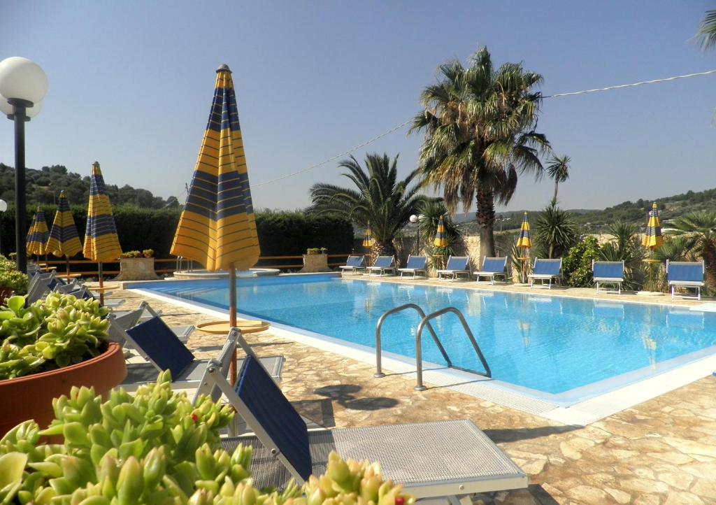 维耶斯泰Residence Palm Garden的一个带椅子和棕榈树的度假村游泳池