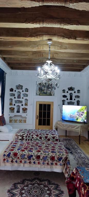 布哈拉Barlos XVIII的一间卧室配有一张大床和一个吊灯。