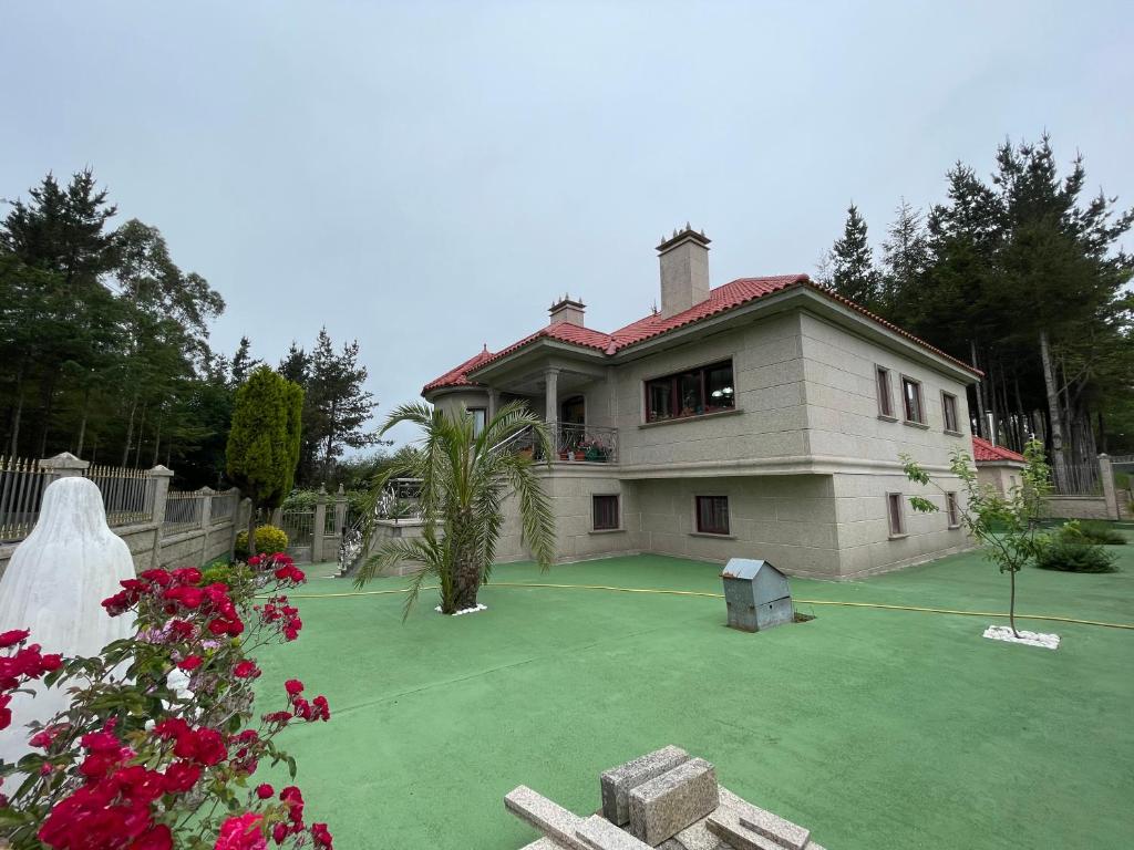 拉科鲁尼亚Impresionante casa con parcela en la naturaleza的前面设有网球场的房子