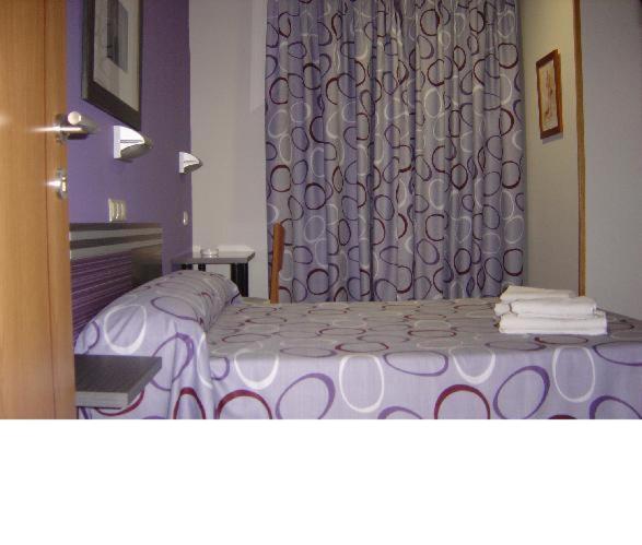 瓜达拉哈拉里卡波萨达旅馆的一间卧室配有紫色的床和窗帘
