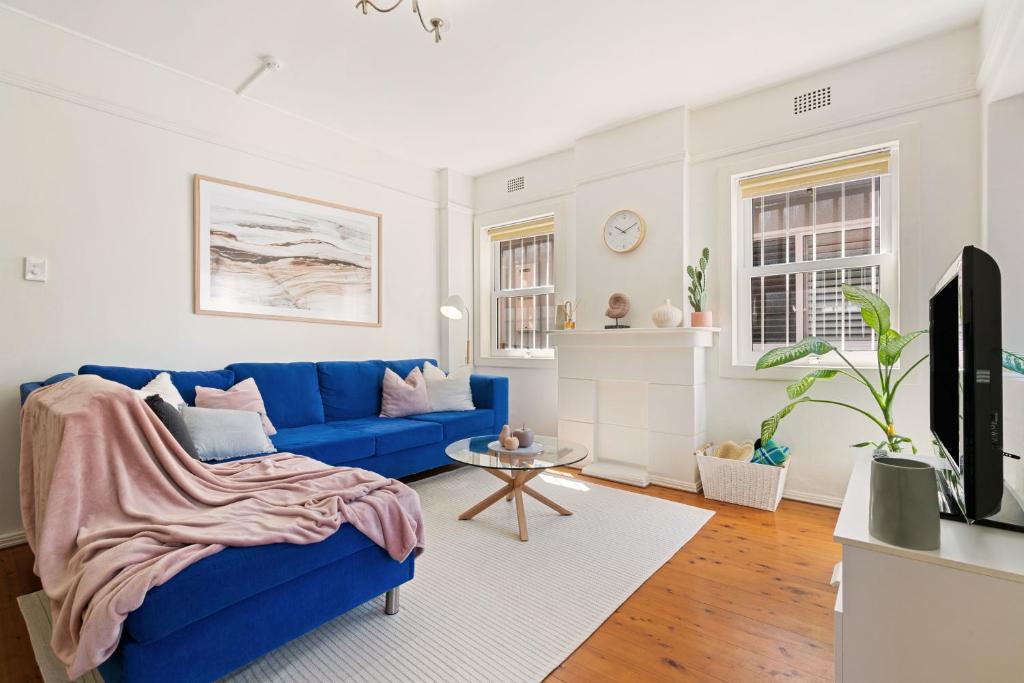悉尼Beach-side North Bondi的客厅配有蓝色的沙发和电视