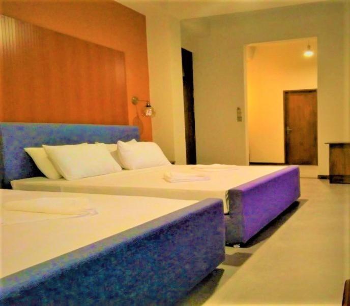 阿努拉德普勒Sooriya Wessagiri Resort的酒店客房配有两张紫色床铺。