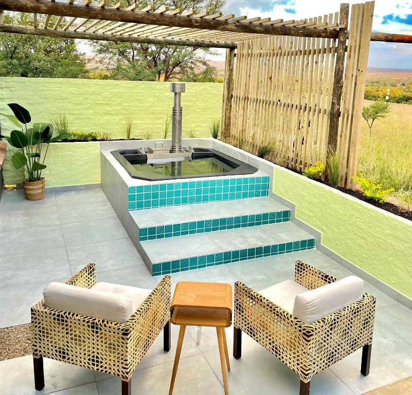 比勒陀利亚HAVANA VILLA - Pretoria East Luxury Villa的一个带热水浴缸和两把椅子的庭院