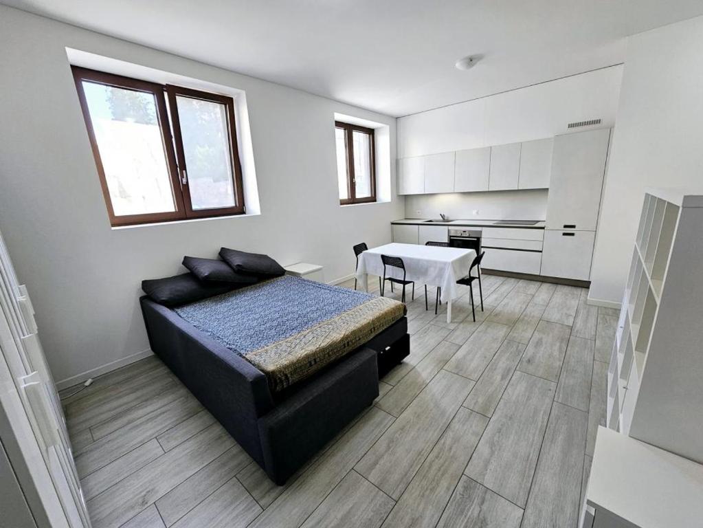 门德里西奥Monolocale a Mendrisio的一间卧室配有一张床铺和一张桌子,还设有一间厨房