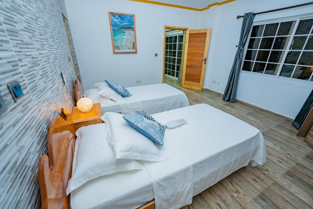马埃岛Paradise Breeze Apartment的一间卧室设有两张床和窗户。