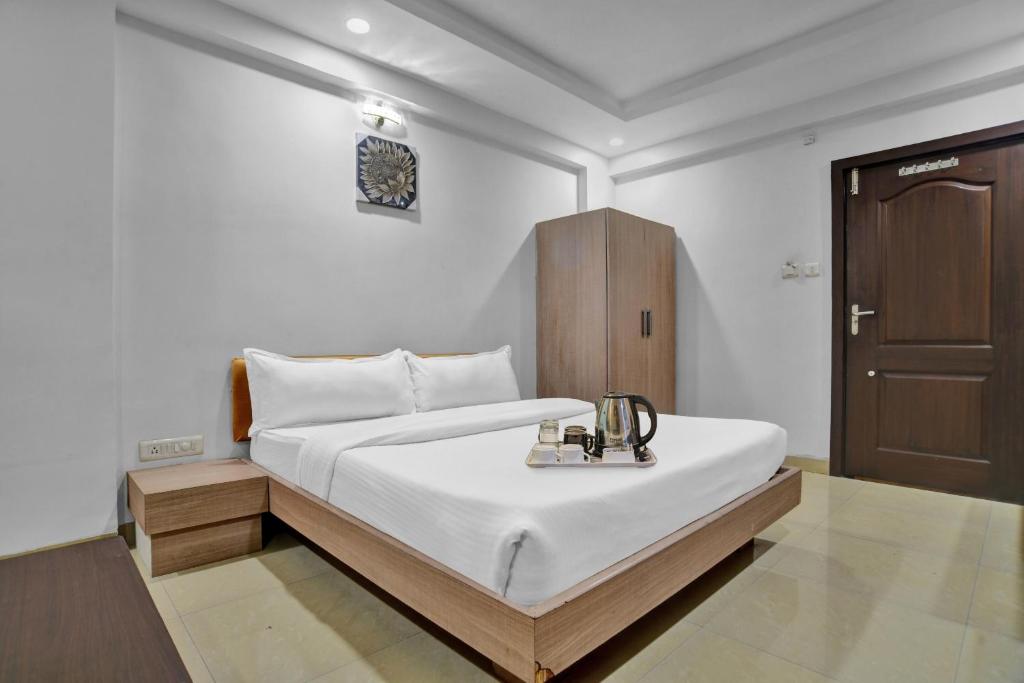 印多尔Townhouse Hotel Divya Palace的一间卧室配有一张床和一个木制橱柜