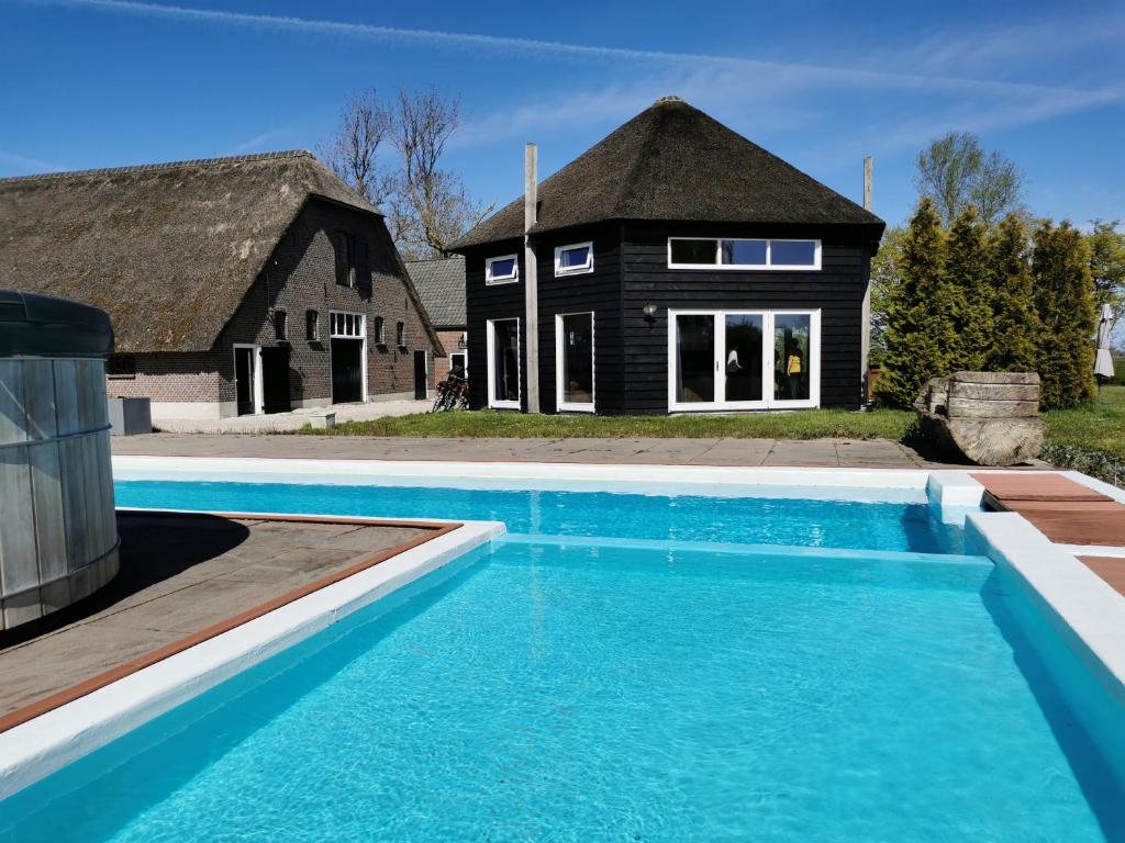 武尔登Vacation house Hooihuys的房屋前有游泳池的房子
