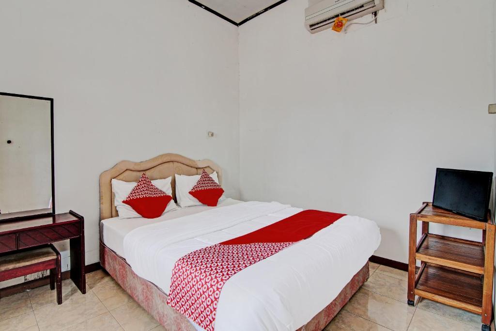 北干巴鲁OYO 92331 Rindu Sempadan Cottage的一间卧室配有一张带红色枕头的床