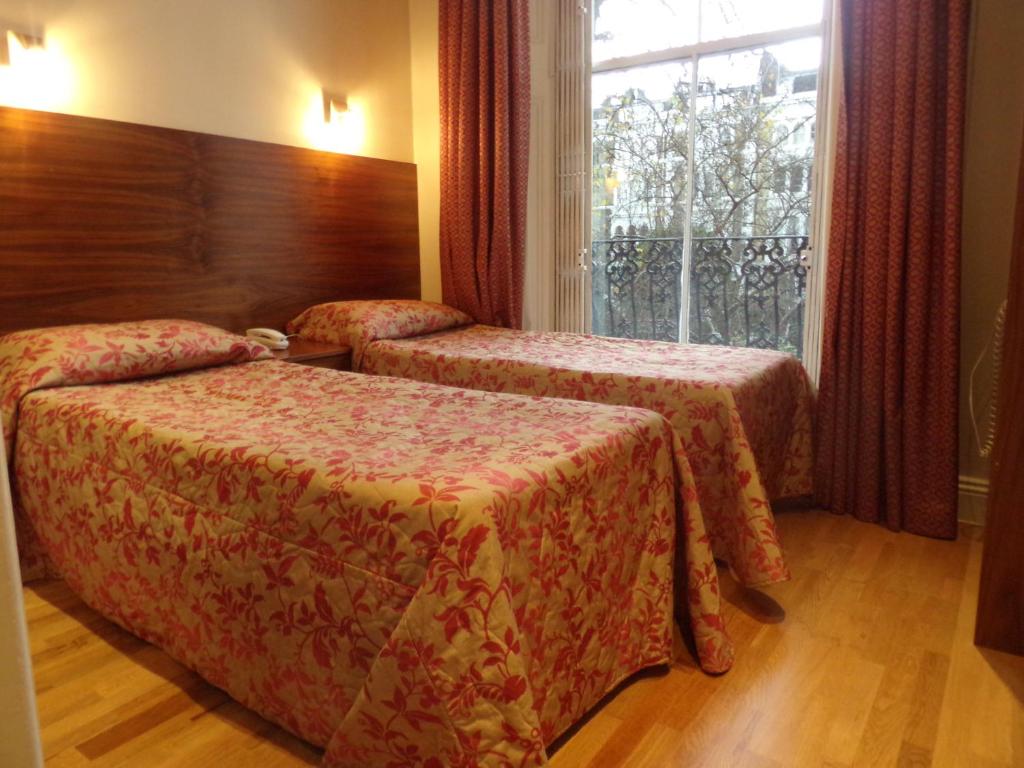 伦敦维治伍德酒店的酒店客房设有两张床和窗户。