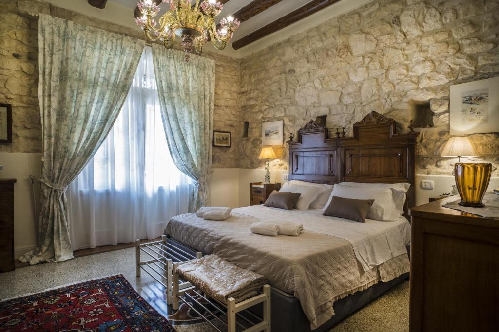 维罗纳Il Calamaio的一间卧室设有一张大床和一个大窗户