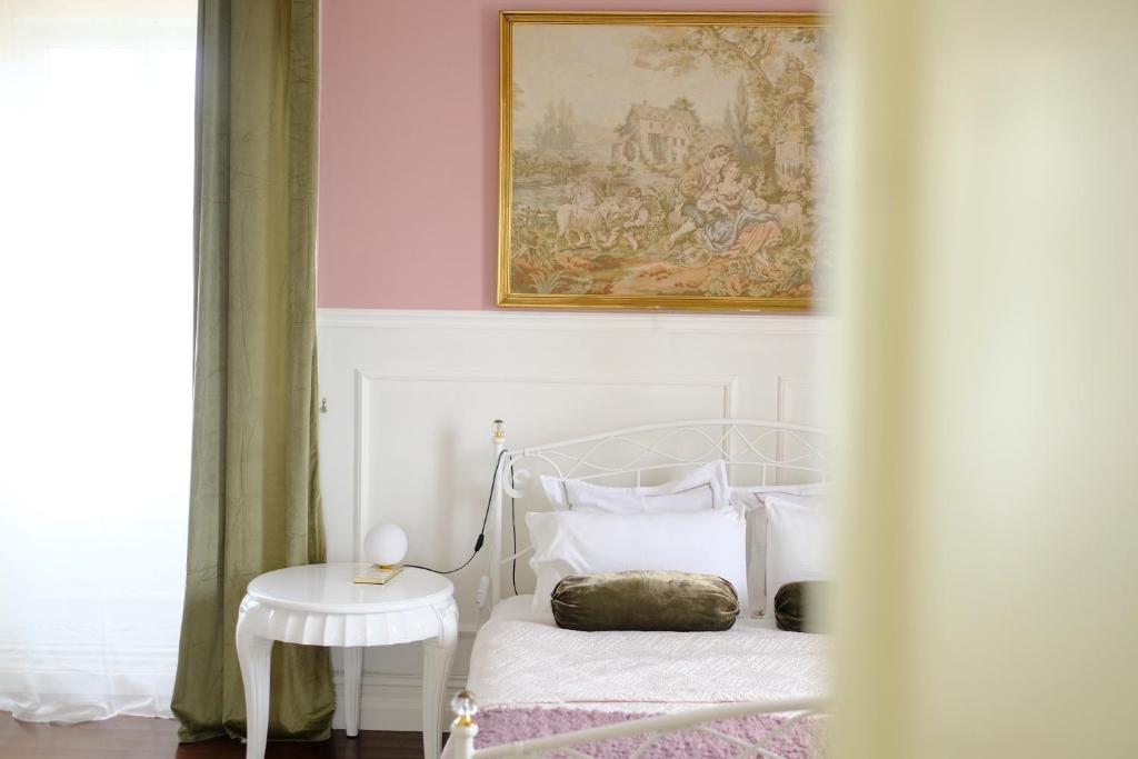 VárzeaVilla Várzea - Garden Suite的白色的卧室配有一张床,墙上挂着一幅画