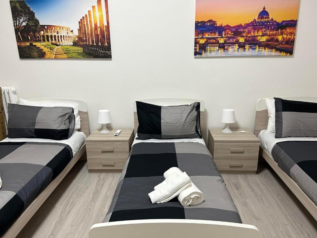 罗马Palmira's Rome Sweet Home的一间卧室配有两张床,墙上有两幅画作