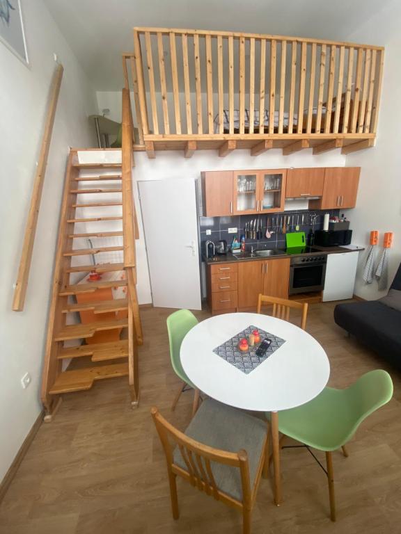 尼萨河畔亚布洛内茨Apartmán v Lesní的一间带桌椅和楼梯的客厅