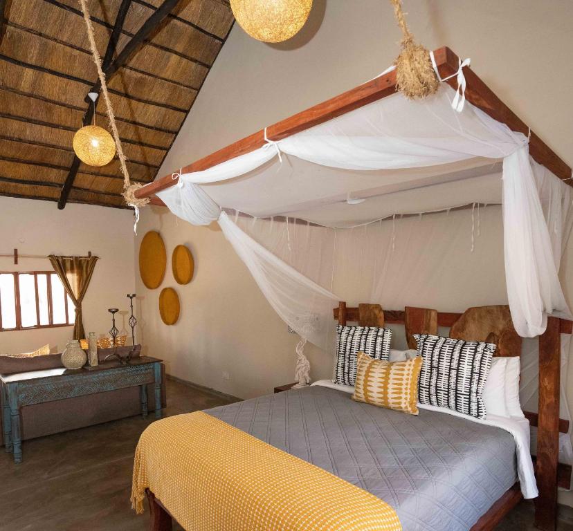 DeteGwango Elephant Lodge的一间卧室配有一张带天蓬的床