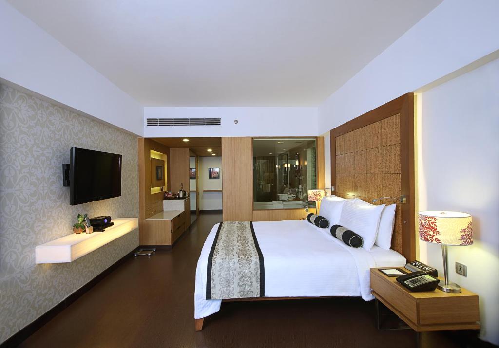 艾哈迈达巴德Fortune Select SG Highway, Ahmedabad - Member ITC's Hotel Group的酒店客房设有一张大床和一台电视。