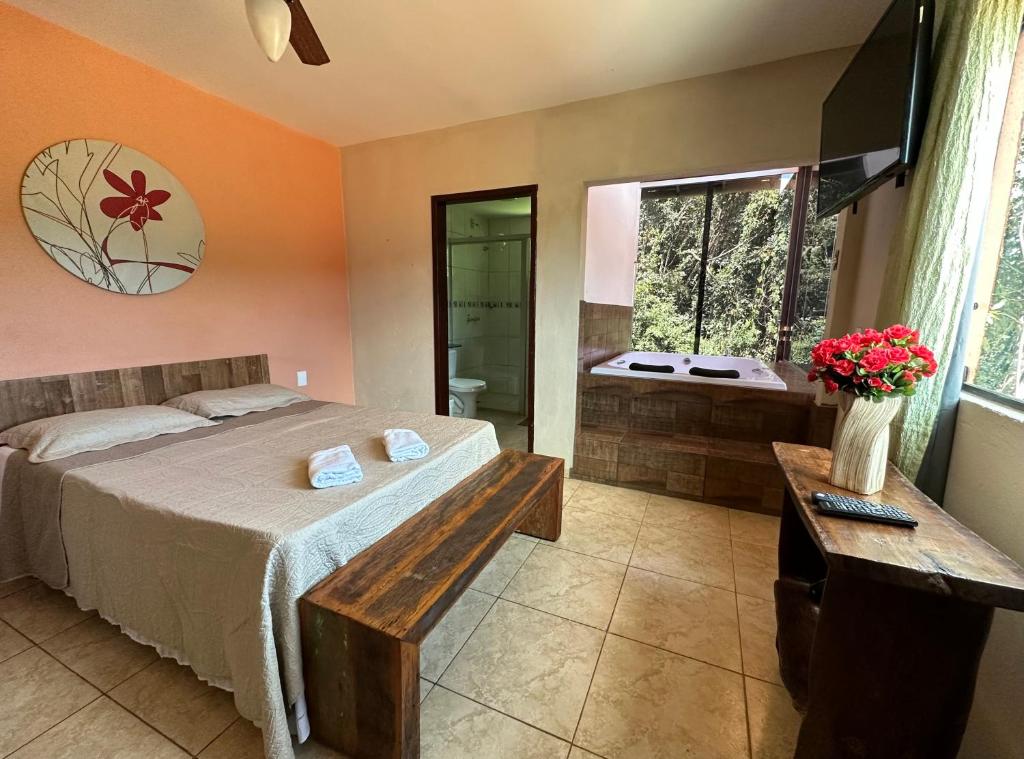 马卡科斯Macaco Prosa的一间卧室配有一张床,浴室设有浴缸