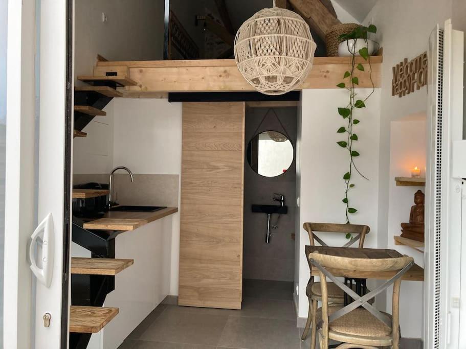 BullionL'Oxalis villa (Le Cocon)的客房设有一张高架床、一张桌子和一把椅子