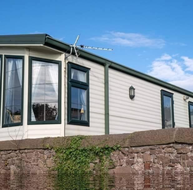 Saint CyrusWrights Retreat 4 Lunan View St Cyrus Caravan Park的白色的房子,有黑窗和砖墙